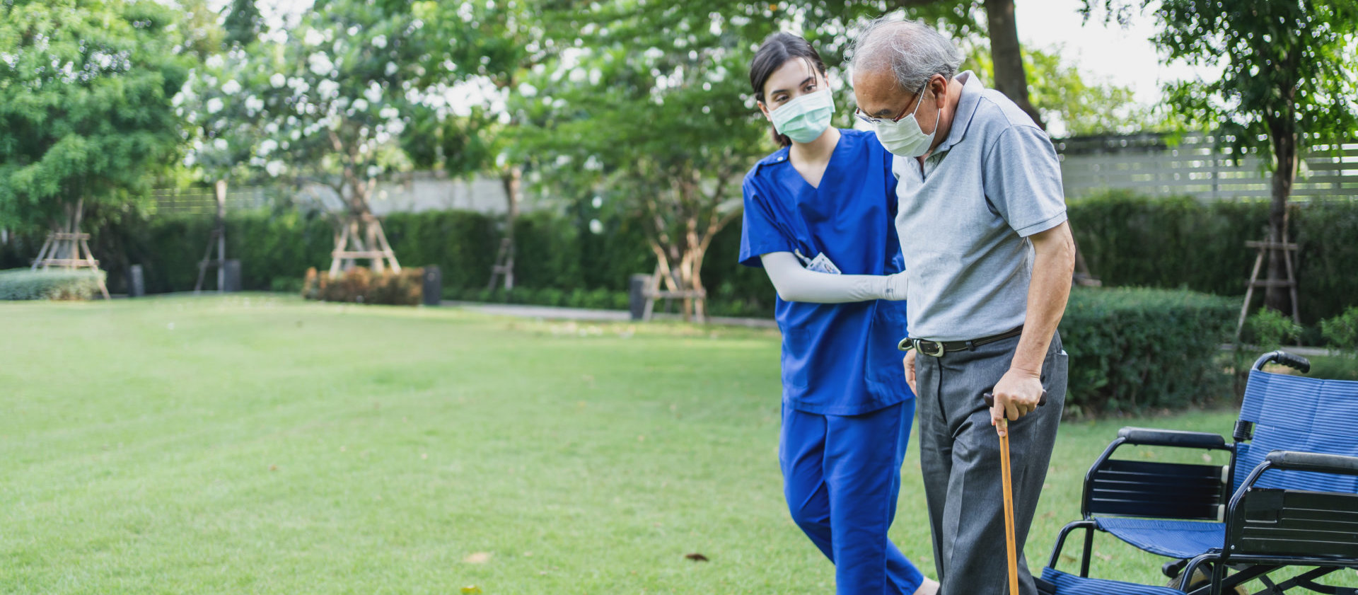 a female caregiver assisting an elderly man