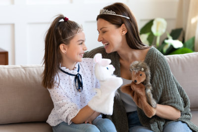 young girl and woman playing with puppets