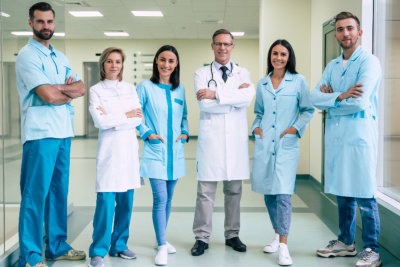 nurse holding folders with other nurses in background