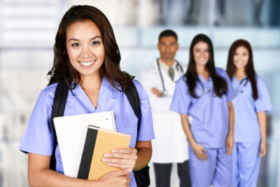 nurse holding folders with other nurses in background